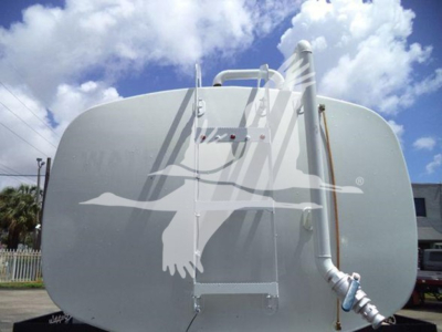 Large cylindrical horizontal propane tank on a Ford F650 truck trailer with protective plumbing and fittings visible.