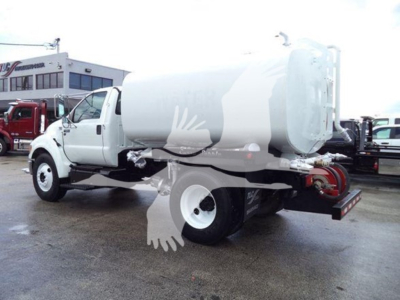 2015 Ford F650 water tanker truck side view showing cylindrical tank and rear hoses.