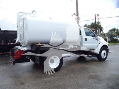 Ford F650 dump truck rear quarter view with tank and dual rear wheels; side view shows white cab and cargo tank.