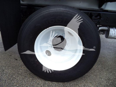 Truck wheel with white rim and tire showing hub, visible undercarriage; part of Ford F650 listing.