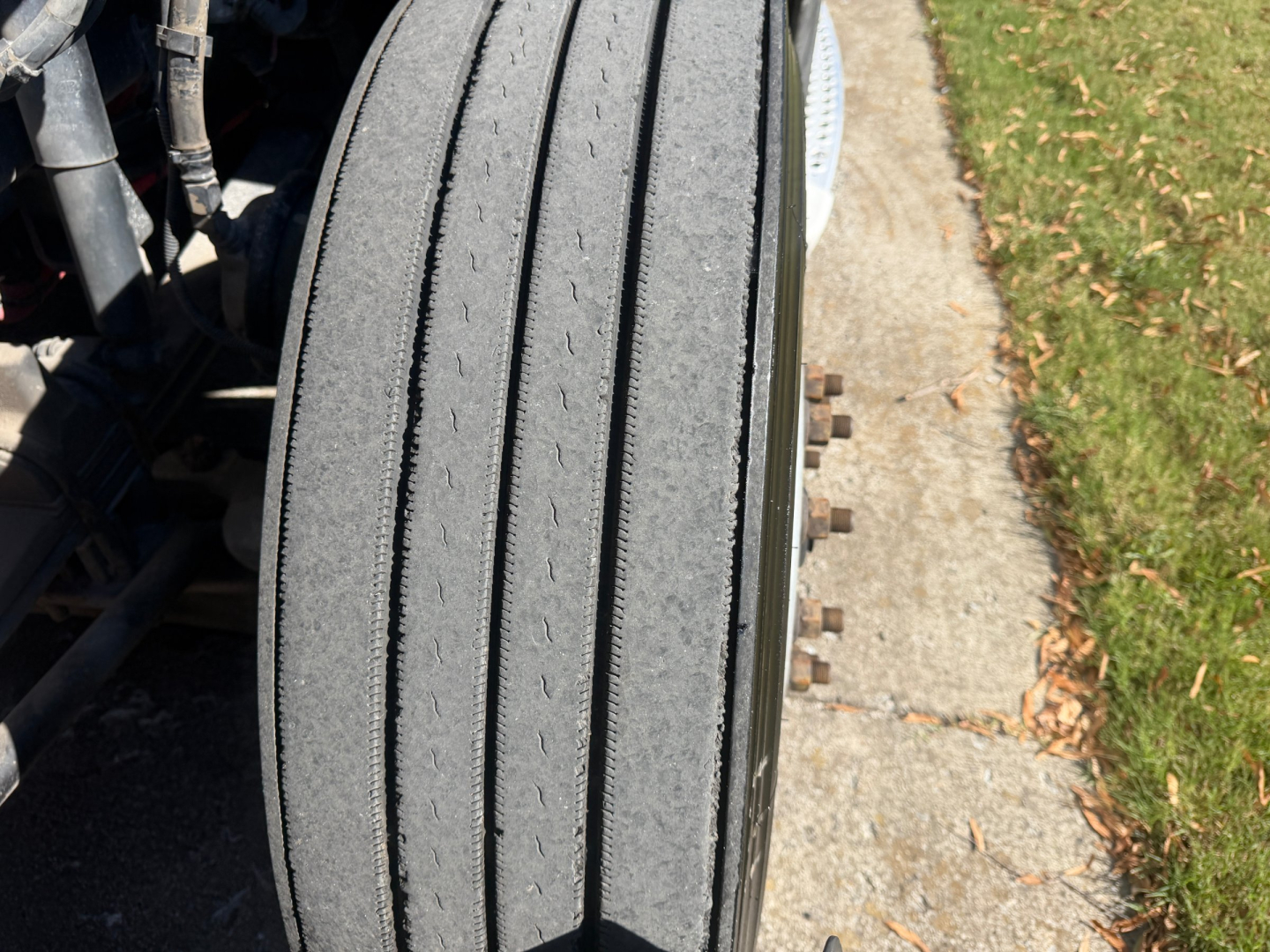 Kenworth T680 front wheel tread and fender view showing twin front axle and tire surface.