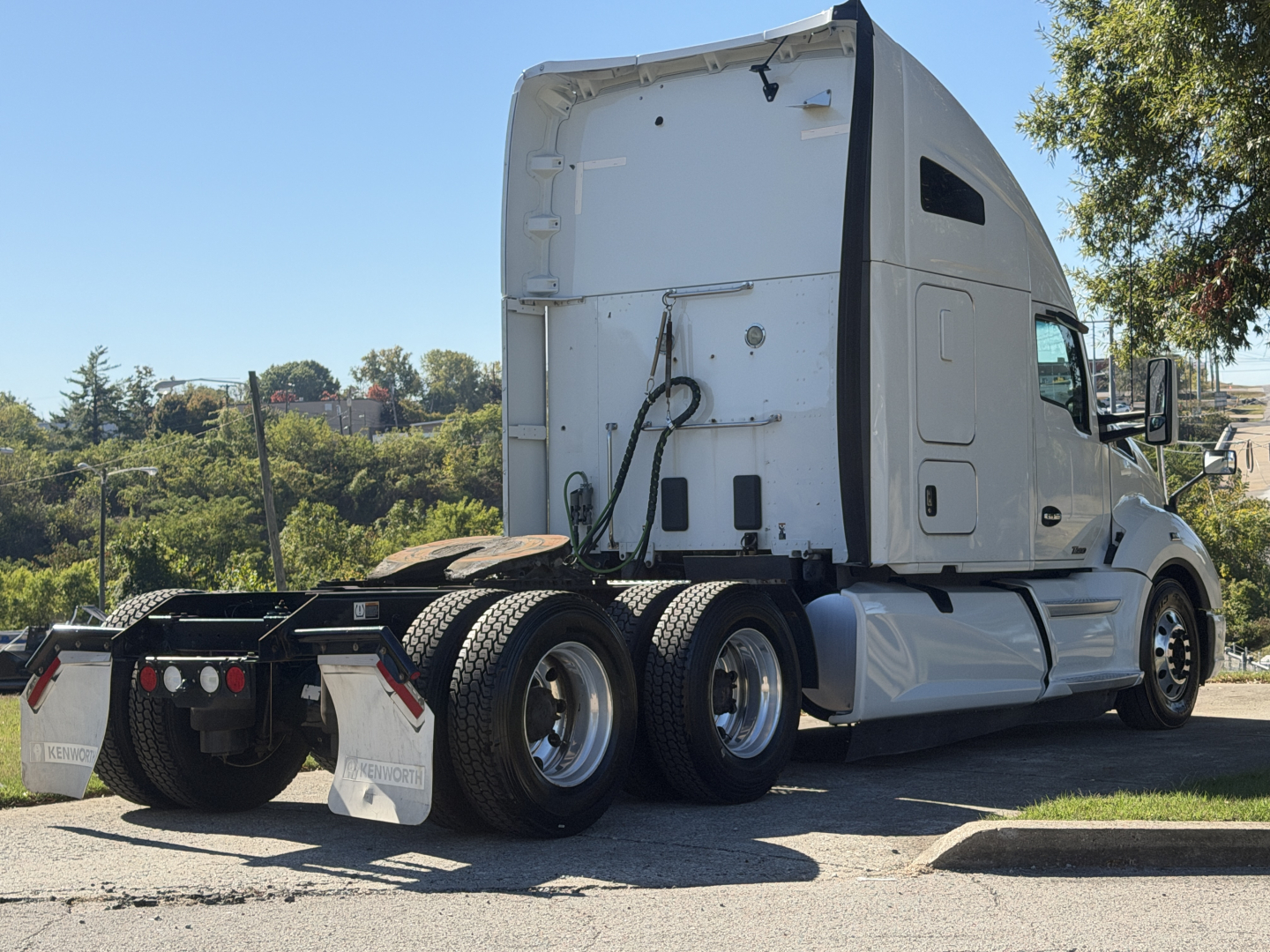 Kenworth T680 sleeper cab tractor rear view showing chassis and dual rear axles.