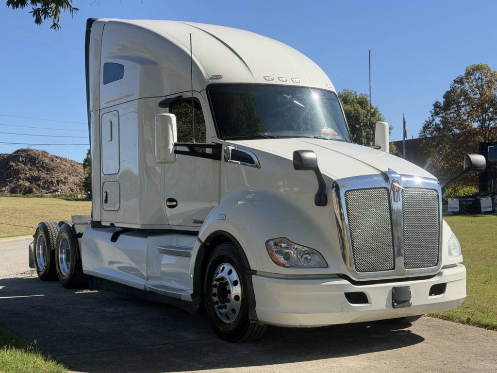 Kenworth T680 tractor-trailer in white, side view showing cab, grille, headlights, front bumper, mirrors, and three-axle configuration with dual rear sets.