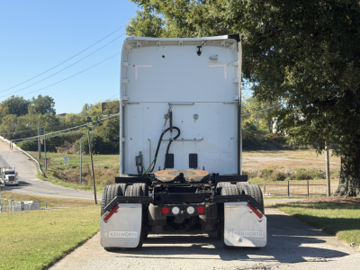 Kenworth T680 rear view showing dual rear tires, mud flaps, and rear bumper with reflectors.