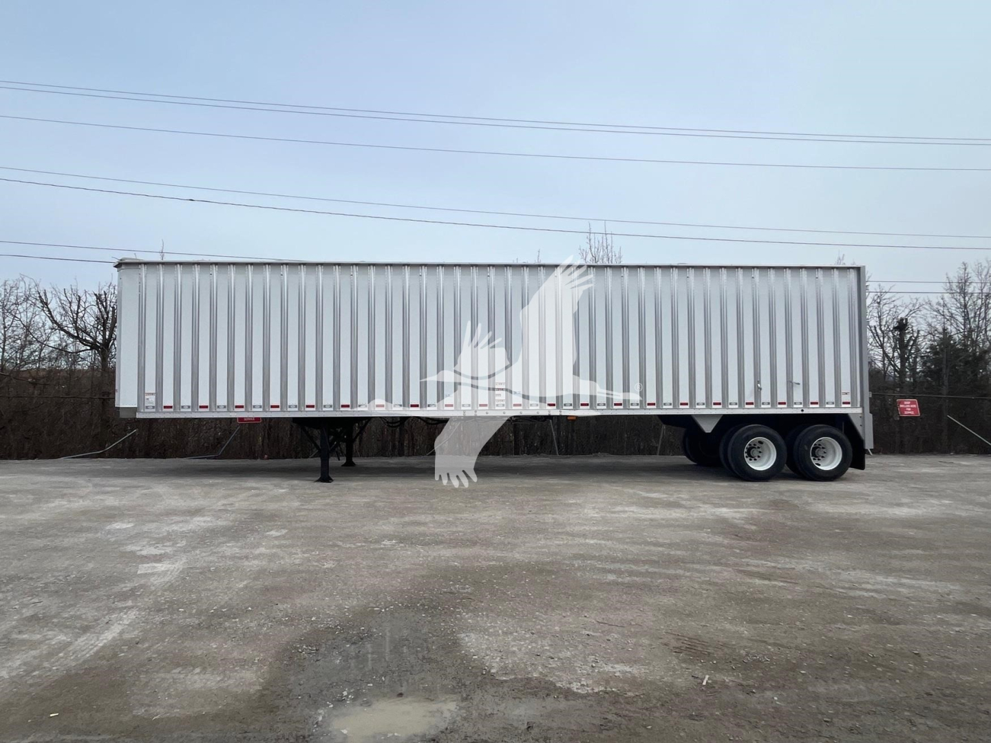 Trailer side view showing a new Dorsey walking floor trailer with silver corrugated body and dual rear axles.