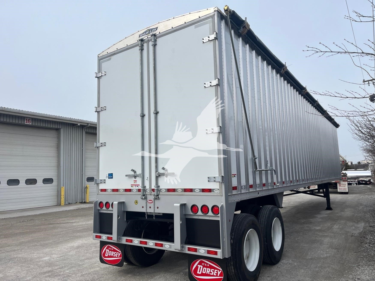 Dorsey walking floor trailer rear and side view showing rear doors and dual axles with tires.
