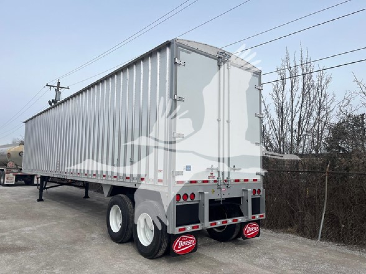 New Dorsey walking floor trailer rear/right-side view showing dual rear doors, tandem axles, bumper with Dorsey mudflaps, and reflective tape.