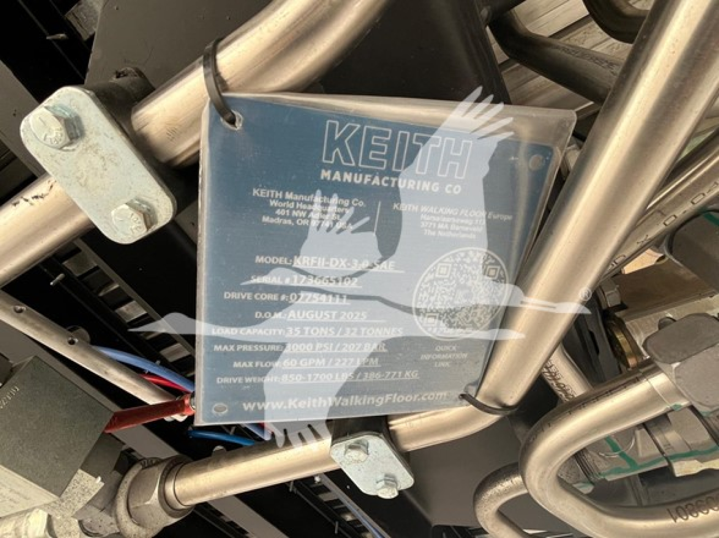 Keith Manufacturing Co label on walking floor trailer showing model and specifications, blue tag with white text mounted under chrome frame.