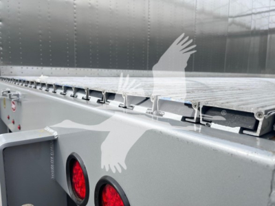 Trailer side and deck of a 2027 Dorsey Walking Floor trailer showing aluminum side panels and rear lights.