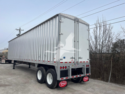 Trailer rear three-quarter view showing Dorsey walking floor trailer with dual rear doors and tandem axles.