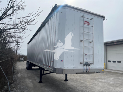 Dorsey walking floor trailer side view showing 2027 model with hitch, landing gear, side ladder, and eagle decal on aluminum surface.