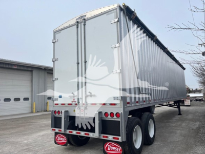 Dorsey walking floor trailer rear and side view showing gray aluminum body with doors, dual rear axles, mud flaps with Dorsey logo, and queen-style landing gear.