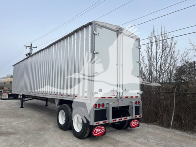 New Dorsey walking floor trailer rear/right-side view showing dual rear doors, tandem axles, bumper with Dorsey mudflaps, and reflective tape.