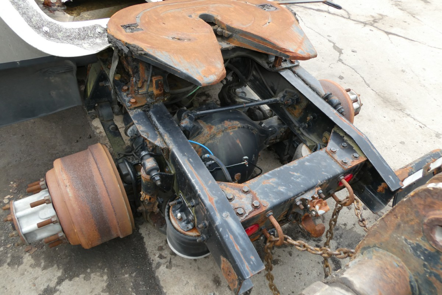 Freightliner Cascadia 113 front axle area showing rusty wheel hubs and exposed frame with components.