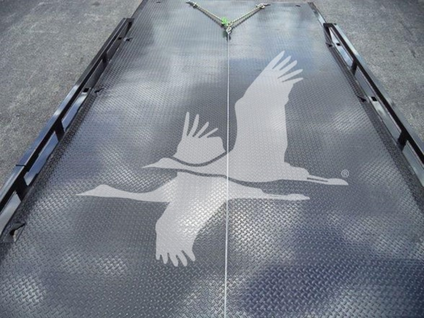 Flatbed truck platform with diamond plate surface and large white seagull decal in the center, seen from above.