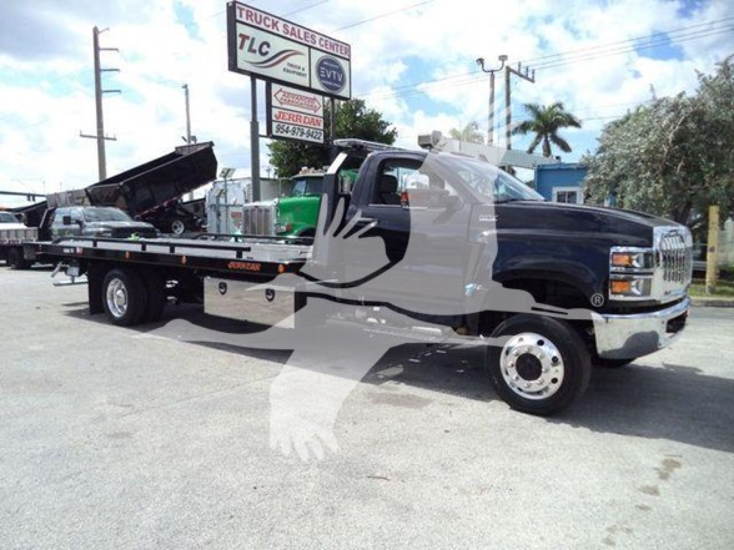 2023 International CV rollback tow truck with black cab and flatbed, VIN sticker and stock number J41635 visible, displaying a large GMC-like front grille.