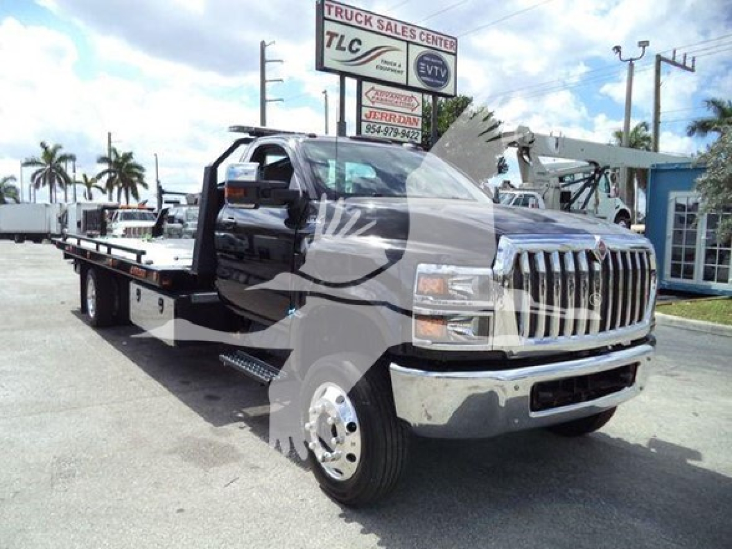 Tow truck chassis with extended flatbed showcasing front chrome grille and dual rear wheels, International CV Series branding not visible in image text.