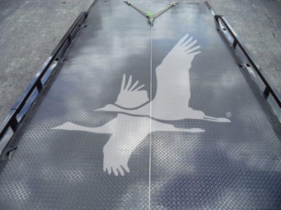 Flatbed truck platform with diamond plate surface and large white seagull decal in the center, seen from above.