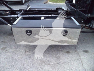 Aluminum toolbox mounted under a truck chassis with pneumatic hoses and frame components visible.