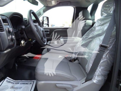 Interior of 2023 International CV truck showing front seats, steering wheel, and plastic-wrapped passenger seat.