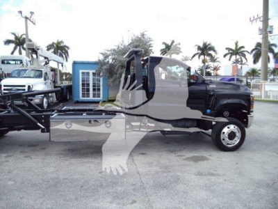Truck cab and chassis of a 2023 International CV rollback truck seen in a dealership lot with palm trees in the background.