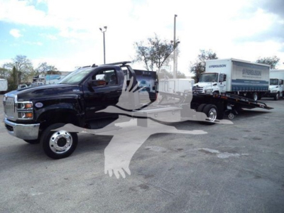 Truck on rollback tow with black cab and white sleeper, attached flatbed with a Ferguson box truck in background; VIN 1HTKTSWK6PH441635 visible in listing.