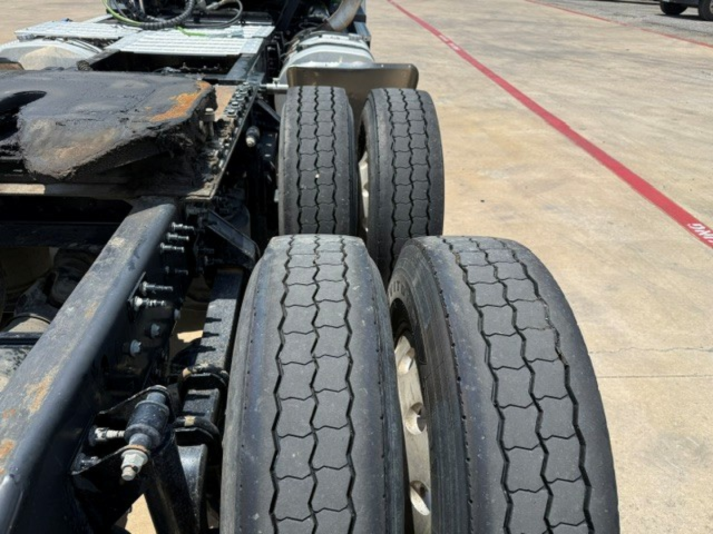 Trucks axle and dual rear wheels of a 2019 Mack Anthem tractor show tires and suspension components in view.