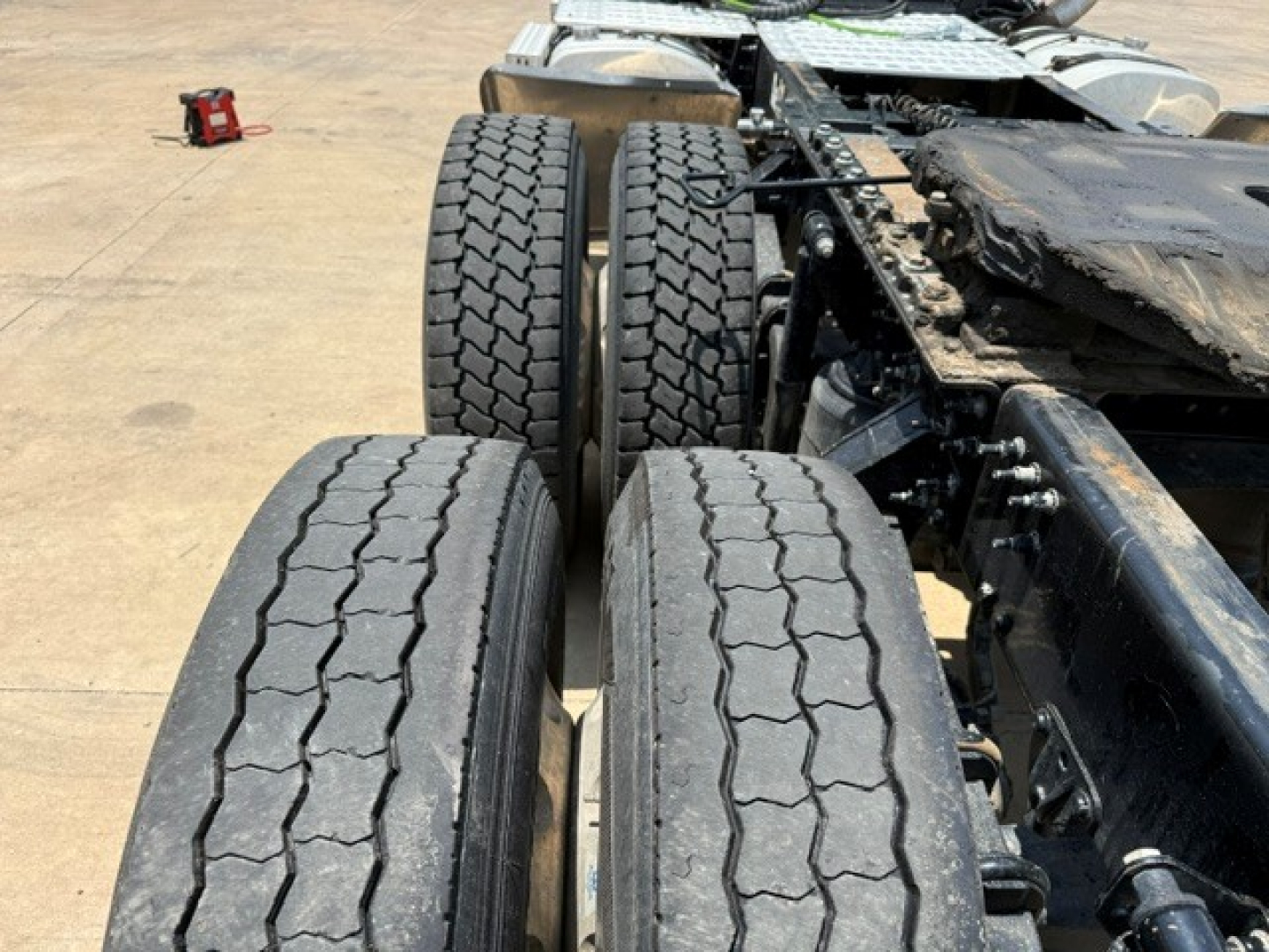 Mack ANTHEM truck chassis with dual rear axles and treaded tires in view.