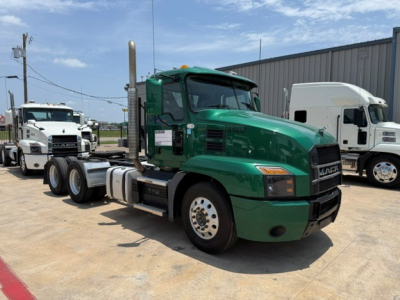 Mack Anthem 2019 conventional daycab truck in green, side view showing fuel tanks, exhaust stack, front grille with Mack emblem.