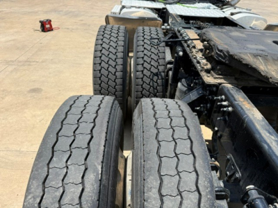Mack ANTHEM truck chassis with dual rear axles and treaded tires in view.