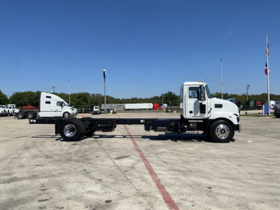 Mack MD6 E cab and chassis truck in a parking lot displaying a long wheelbase with a flatbed frame and front cab, side view.
