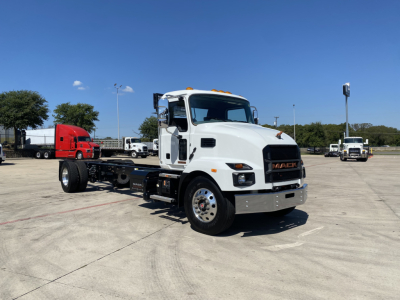 Truck cab and chassis showing Mack MD6 E with white cab and flatbed chassis, front grille and mirrors visible.