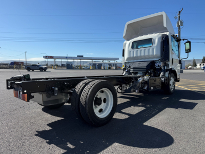 Isuzu NPRXD cab and chassis truck frame with cargo bed removed, front cab and open chassis showing drivetrain and single rear axle.
