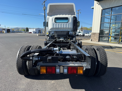 Isuzu NPRXD cab chassis rear view showing dual rear wheels, chassis frame, lights, and towing electrical connectors.