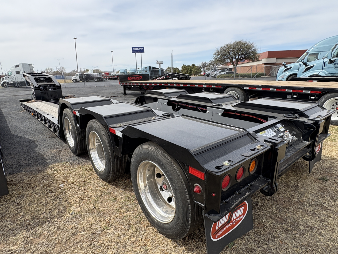 Load King 503/554 lowboy trailer with multiple axles and heavy-duty steel frame, shown from rear-side view.