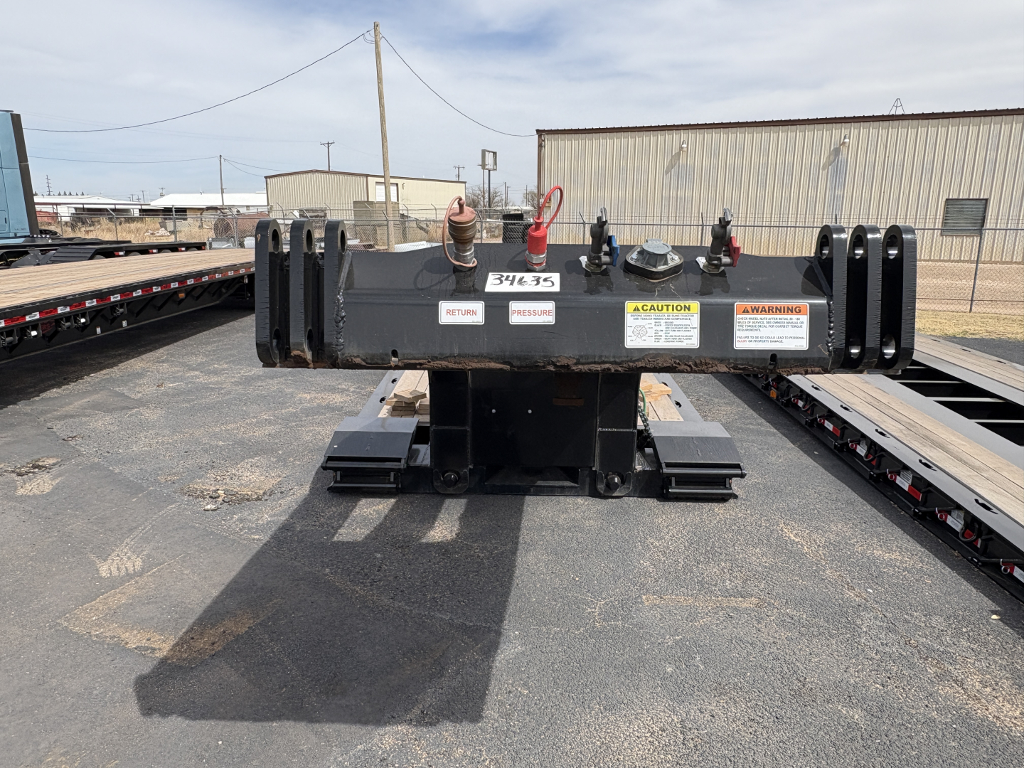 Front view of a Load King 9' 18'' lowboy trailer hitch assembly with safety decals and hooks visible.