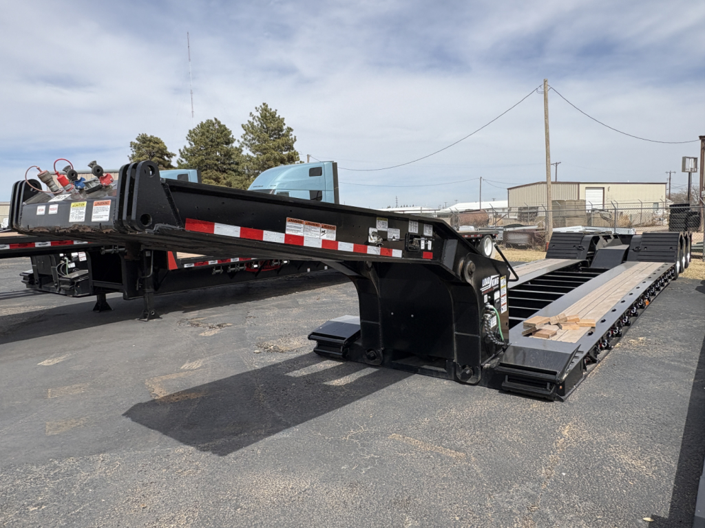 Load King 503/554 lowboy trailer with 9' deck and extended gooseneck, black-painted steel frame, reflective safety markings, and multiple axles.