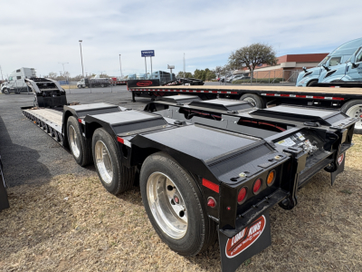 Load King 503/554 lowboy trailer with multiple axles and heavy-duty steel frame, shown from rear-side view.