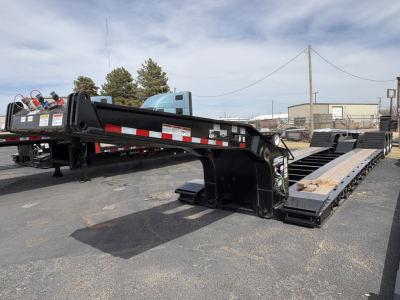 Load King 503/554 lowboy trailer with 9' deck and extended gooseneck, black-painted steel frame, reflective safety markings, and multiple axles.