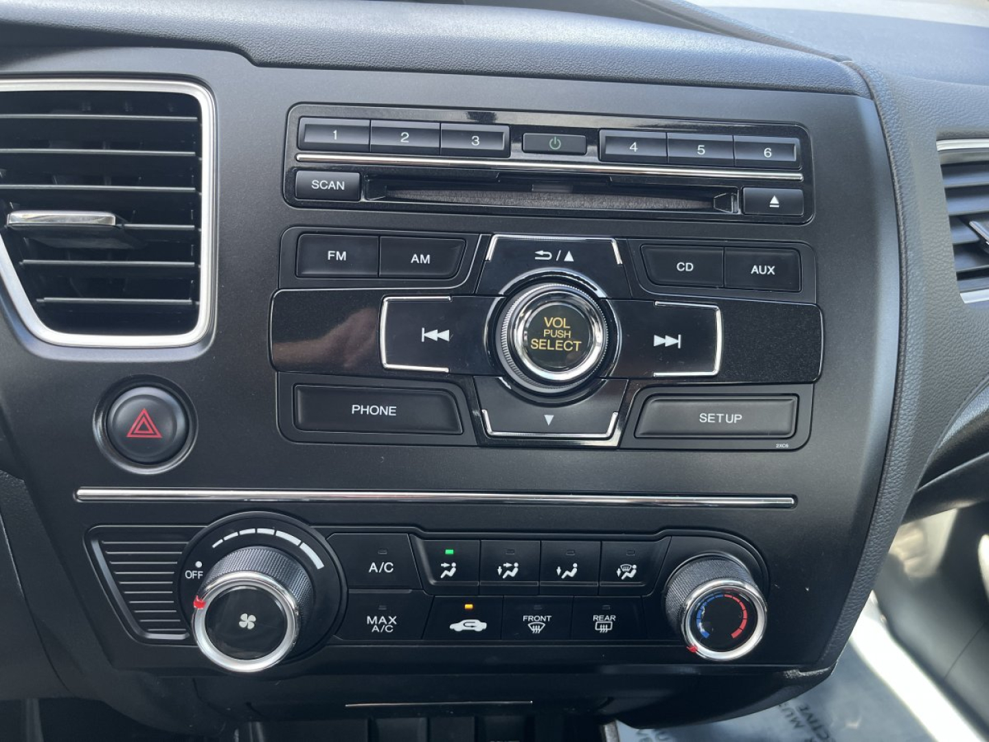 Dashboard center console of a 2015 Honda Civic Coupe showing radio controls, climate control knobs, and USB/CD/AUX buttons.