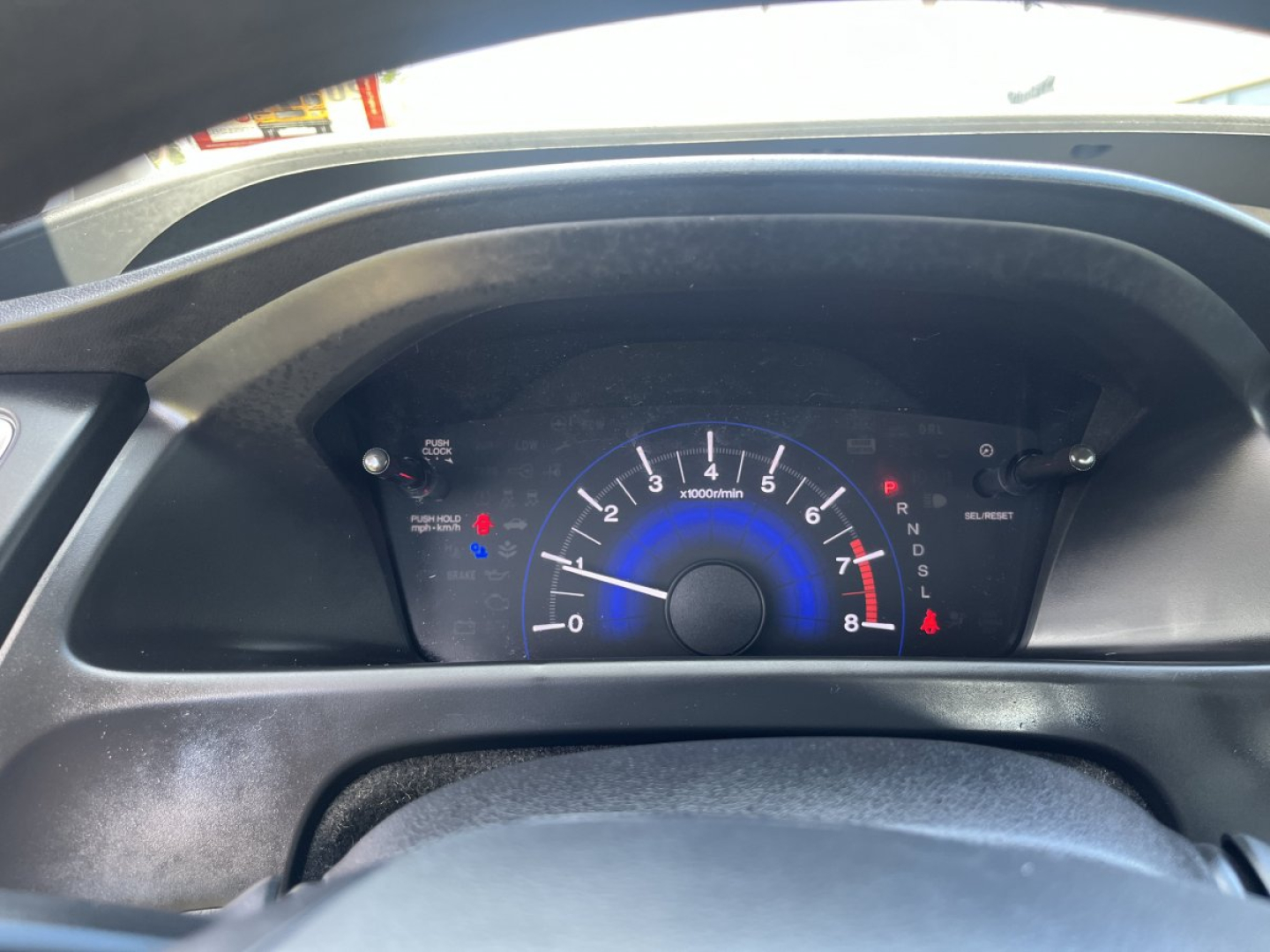Dashboard of a 2015 Honda Civic Coupe showing analog tachometer with blue accents and gear selector indicators.