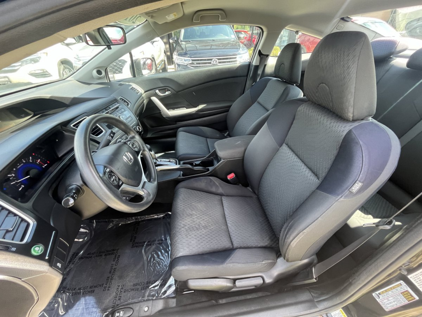 Honda Civic coupe interior showing front seats and dashboard with steering wheel and center console.
