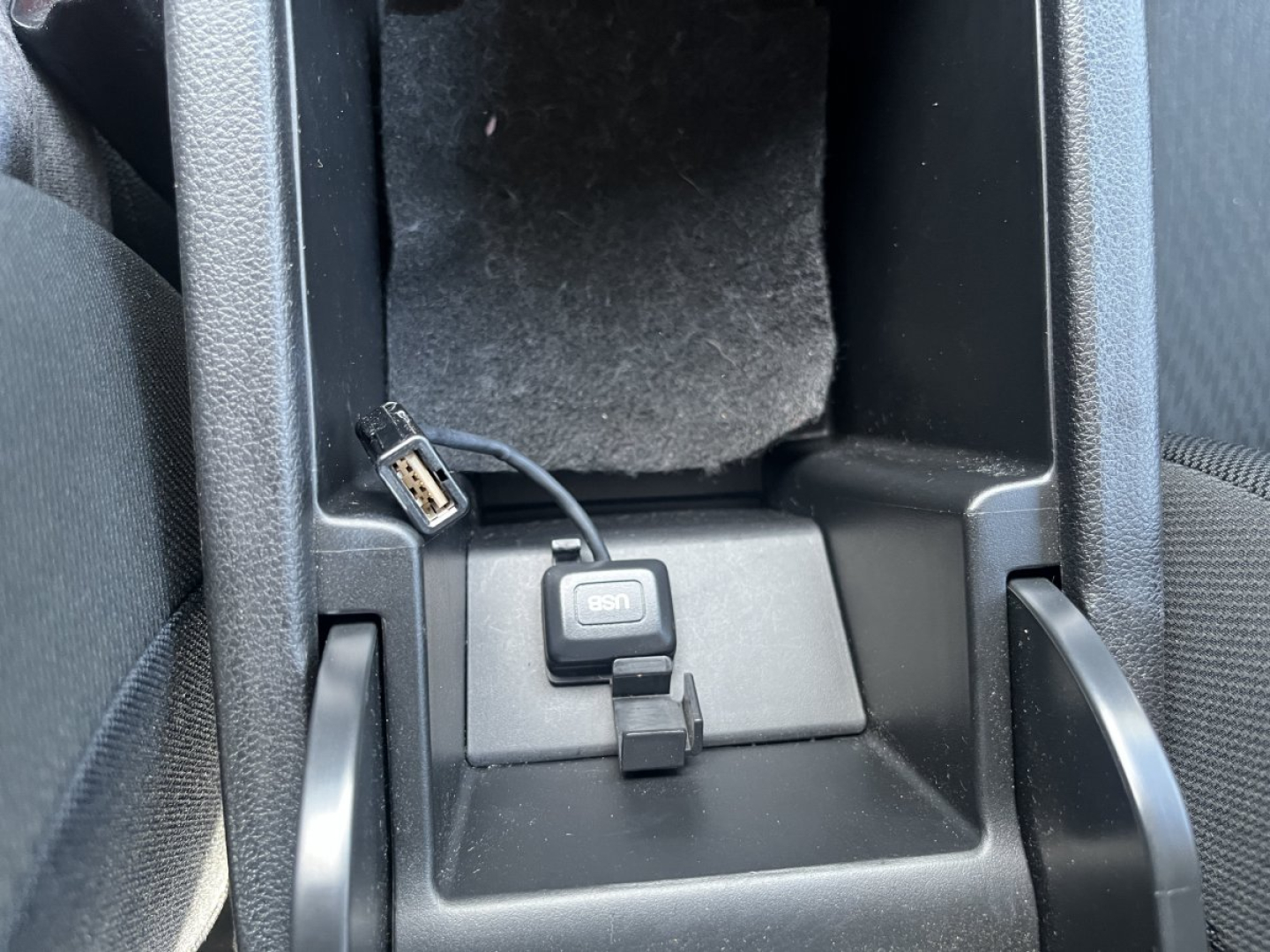 Honda Civic interior showing USB data/charging port and 12V accessory outlet area with a small connector and wiring.