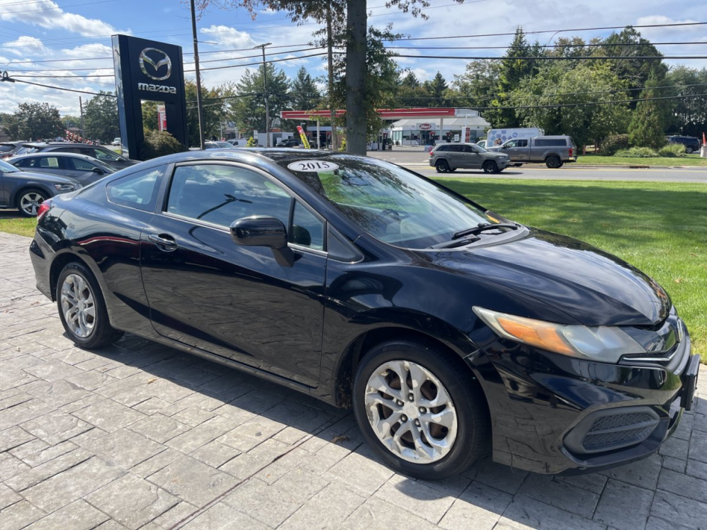 2015 Honda Civic Coupe in black parked at dealership lot with Mazda sign in background