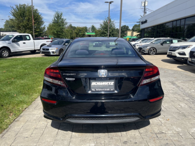 Rear view of a black 2015 Honda Civic Coupe in a dealership lot showing taillights and trunk lid with Honda badge and SCHWARTZ dealer plate frame.