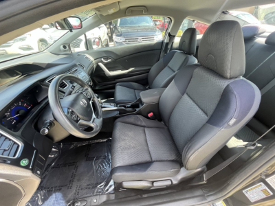 Honda Civic coupe interior showing front seats and dashboard with steering wheel and center console.