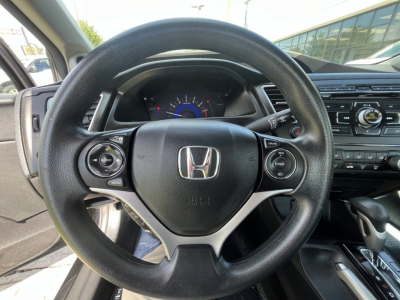 Honda Civic steering wheel and dashboard view in interior showing steering wheel controls and instrument cluster.