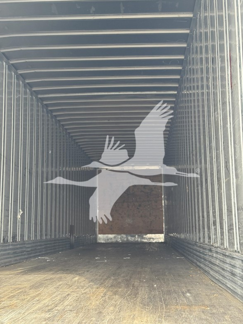 Trailer interior showing spacious cargo area with ribbed metal walls and a bird watermark graphic.