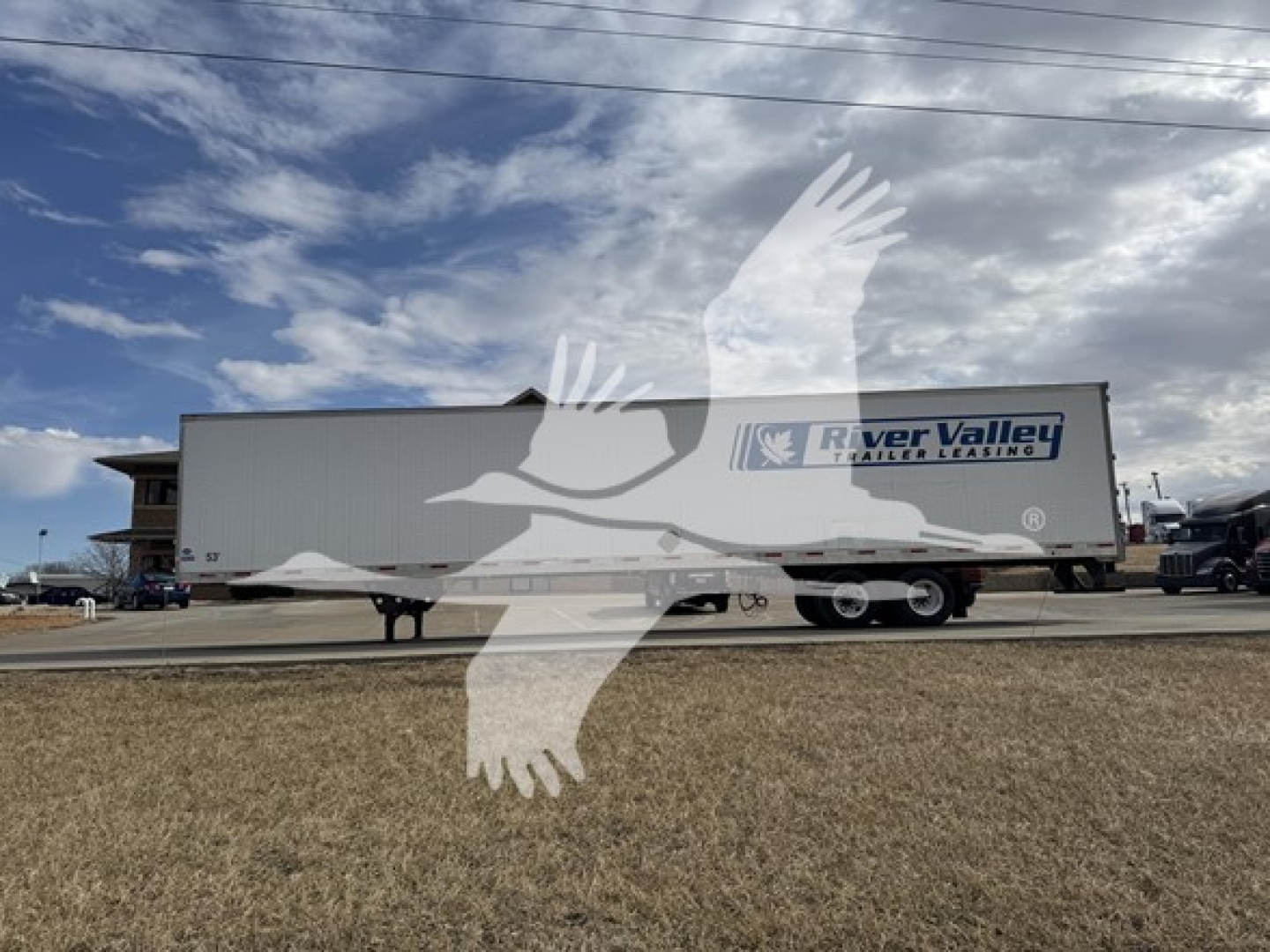 Trailer side view of a River Valley equipment trailer with a River Valley logo, utility 4000Dx trailer, side rails, and multiple axles.