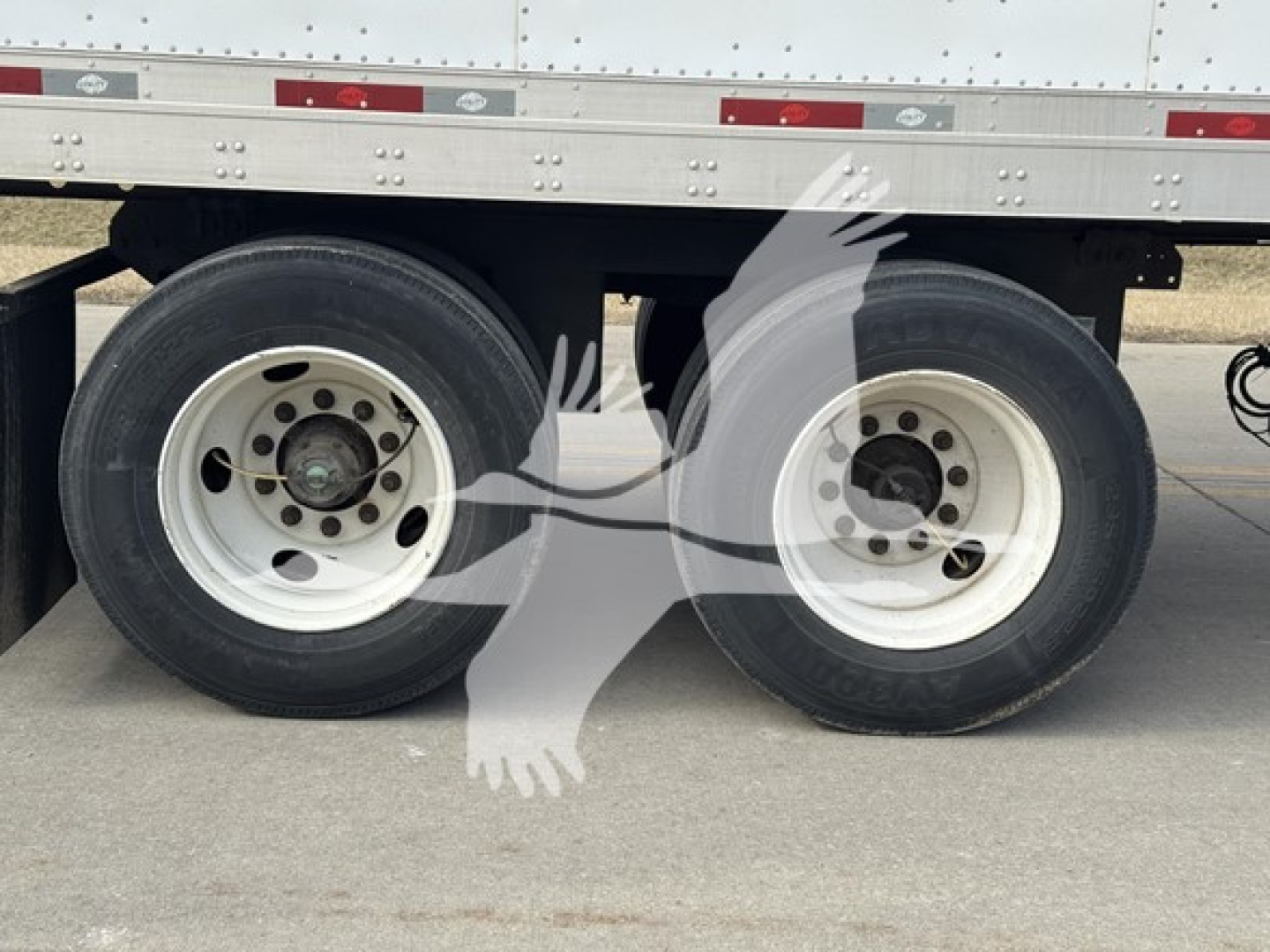 Trailer axles and wheels of a 2014 Utility 4000Dx trailer showing dual rear tires and white rims.